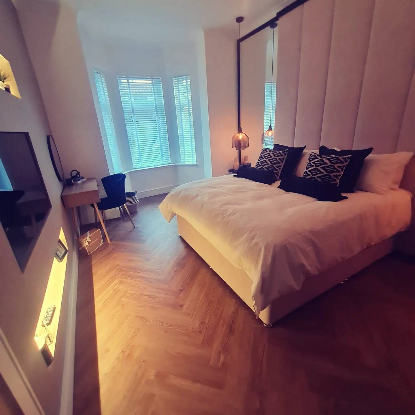 Boutique bedroom with bespoke headboard and parquet flooring